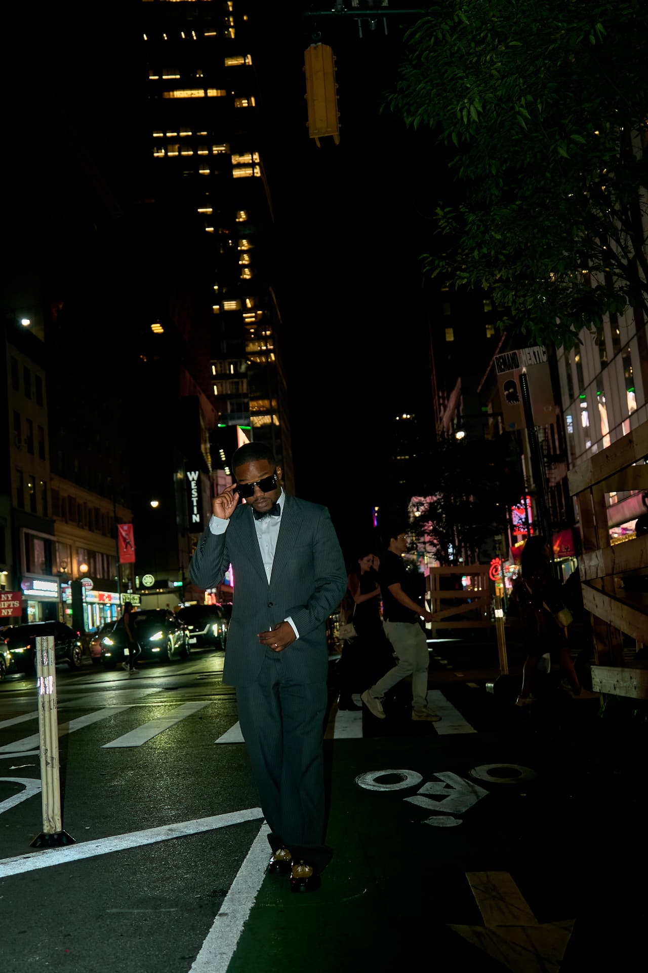 DeSean Kirkland in a tailored suit on a Manhattan street at night